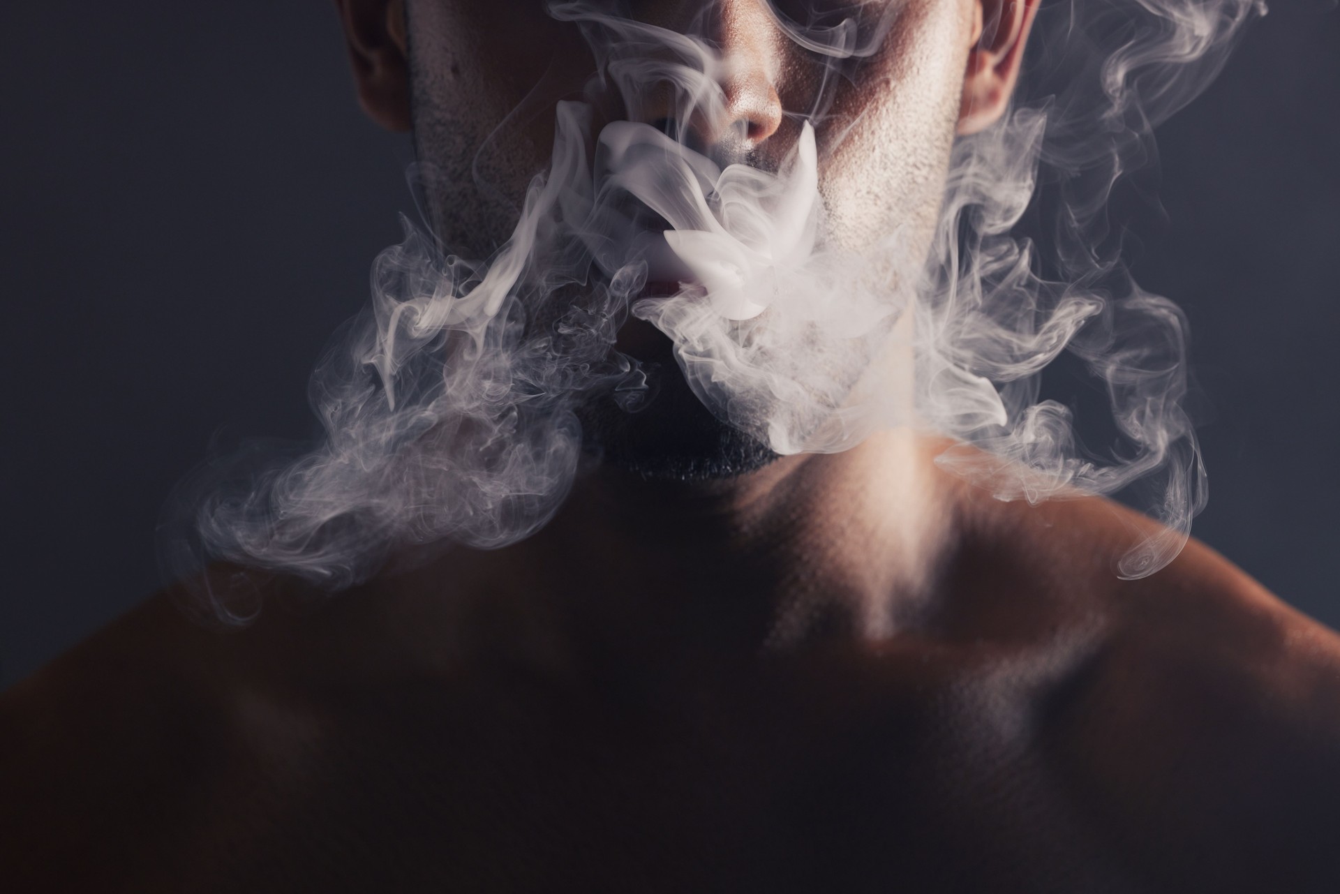 Smoke, cloud and face of man with pollution for marijuana smoker health campaign with zoom. Cannabis, weed and cbd addiction model for smoking habit lifestyle advertising in black studio.
